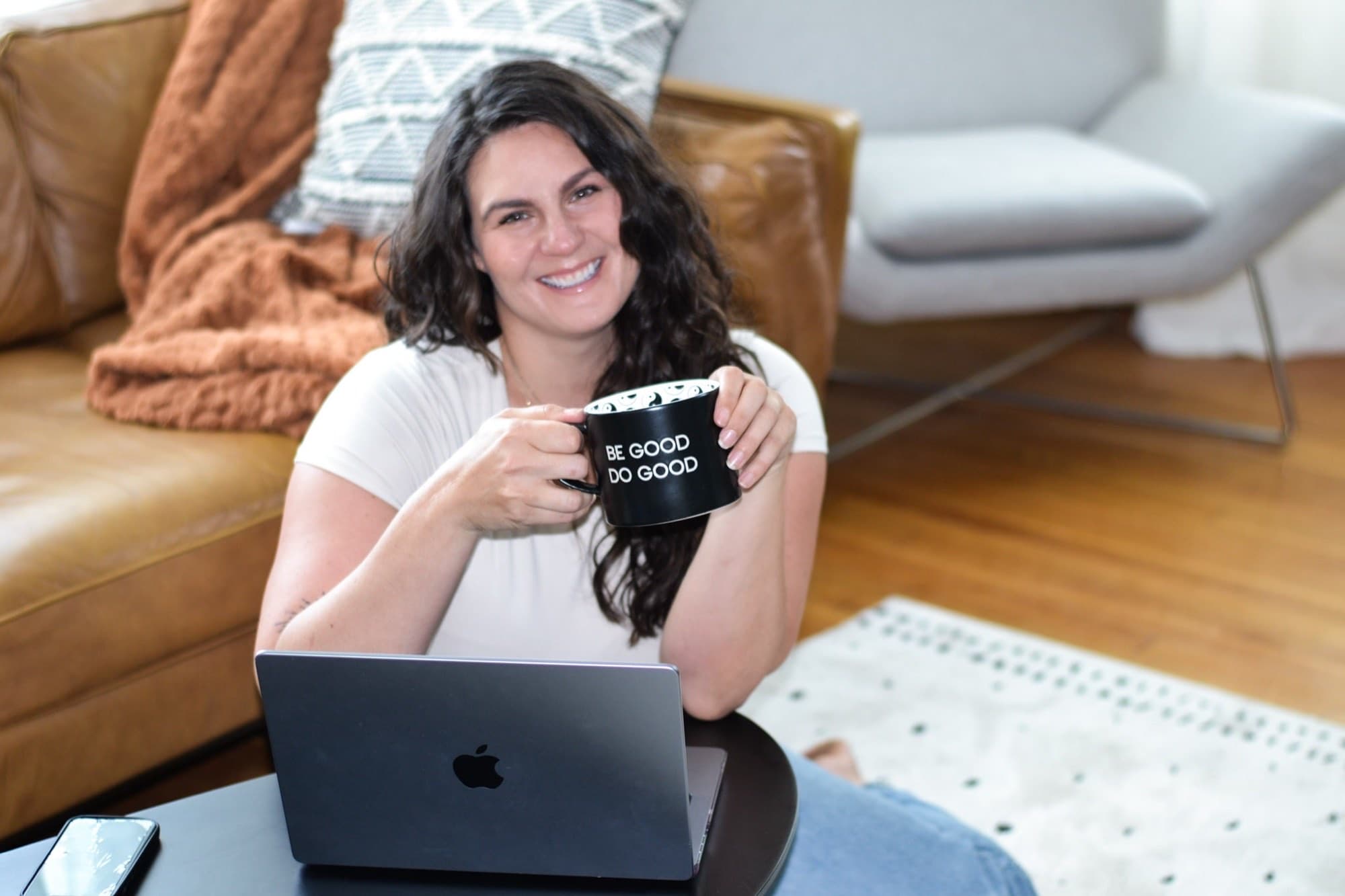 Alana Kane smiling and holding a 'Be Good Do Good' mug