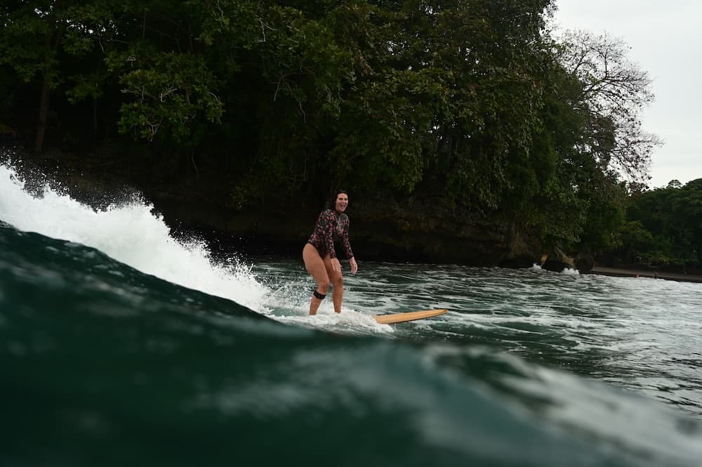 Alana Kane surfing, a metaphor for building an intentional business with courage and balance